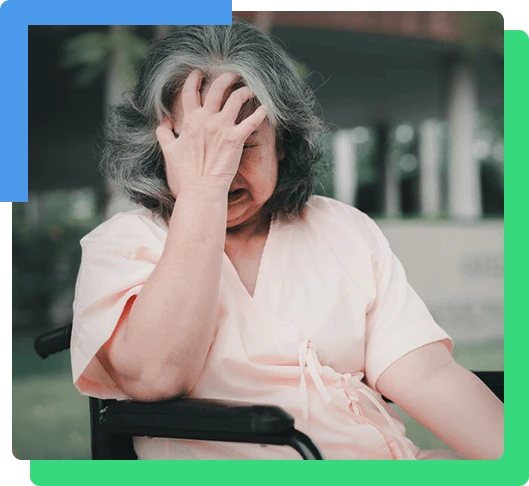 A senior woman in wheelchair who has a severe headache